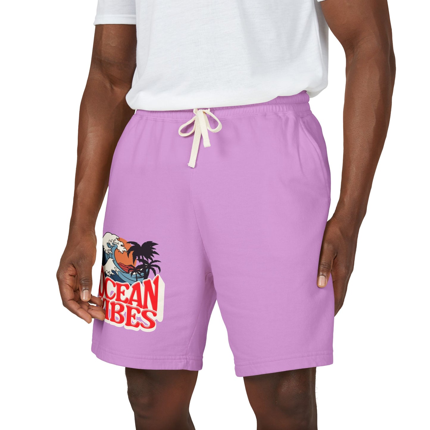 A person wearing lavender-purple drawstring shorts with a graphic print on the left leg that reads 'Ocean Vibes' with a rooster and wave illustration, paired with a white t-shirt against a plain white background. Unique Lightweight Fleece Sweat Shorts in Ocean Vibes Graphic Shop Lightweight Fleece Sweat Shorts in Ocean Vibes for breezy comfort, relaxed style, and an easygoing summer-ready look all day. Refresh your casual rotation with Lightweight Fleece Sweat Shorts in Ocean Vibes—soft, versatile.