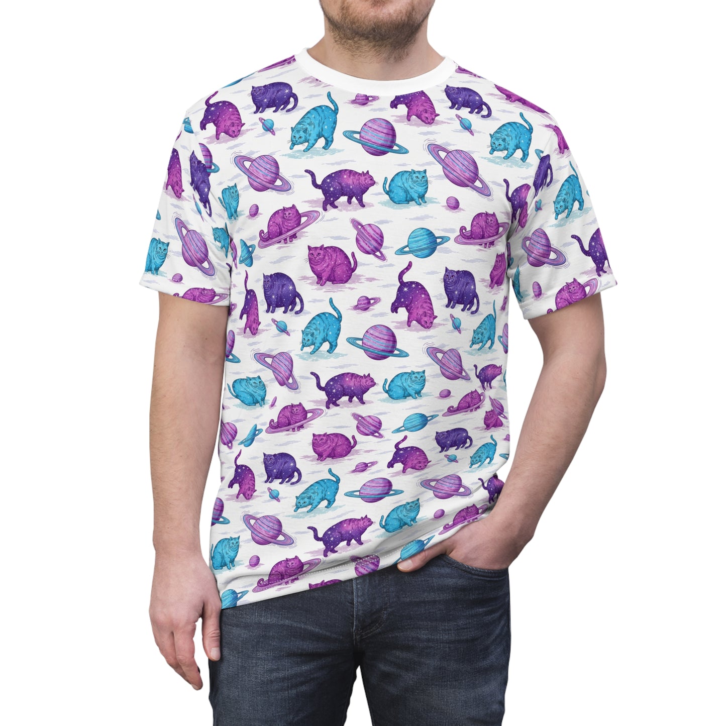 A man wearing a white crewneck t-shirt with an all-over print of purple and blue cats wearing space-themed hats, paired with dark blue jeans, against a plain white background. Chic Chubby Cats Orbiting Planets Graphic T-Shirt for Casual Wear