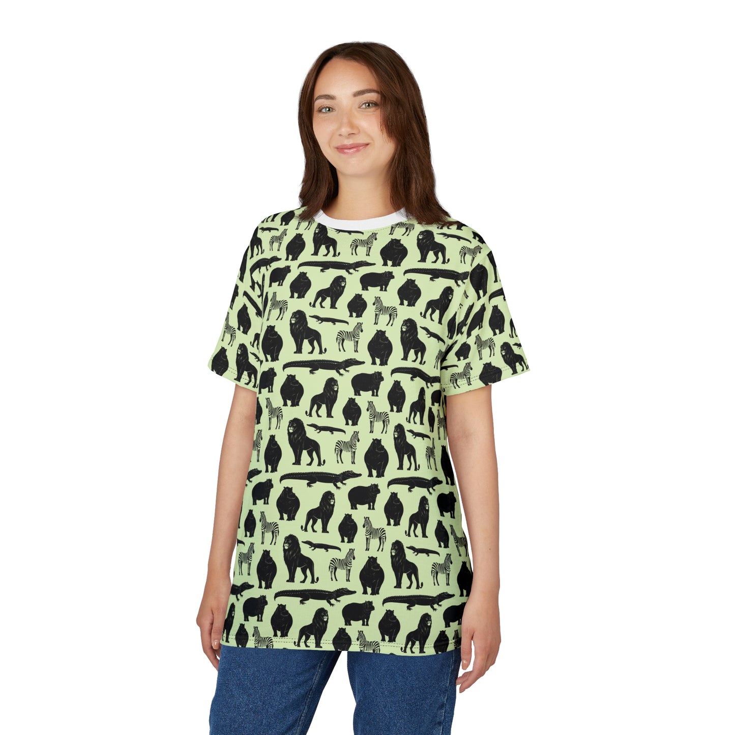 A woman modeling a short-sleeve t-shirt with a repeating black animal silhouette pattern on a light sage green background, paired with blue jeans against a plain white studio background. Comfortable Bold Jungle Safari Animal Pattern T-Shirt for Casual Wear