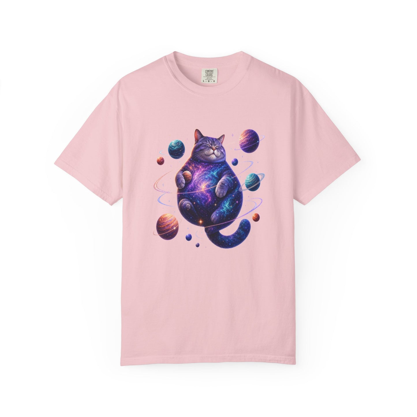 A light pink short-sleeve crewneck t-shirt featuring a colorful graphic of a cosmic, galaxy-patterned cat surrounded by planets, displayed on a clean white background. Comfortable Celestial Feline: Space-Themed Cat T-Shirt for Casual Wear