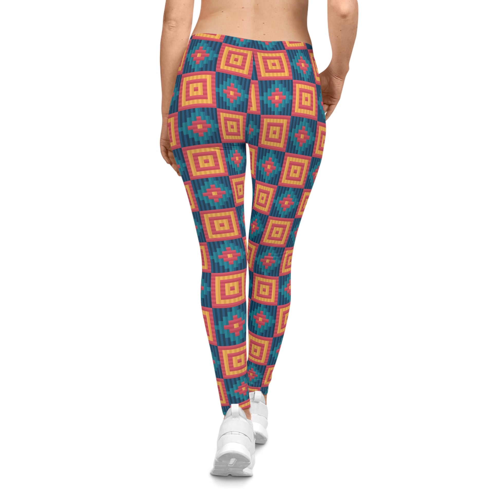 A person shown from the back wearing patterned leggings with a geometric diamond design in teal, orange, and red, paired with white sneakers on a plain white background.