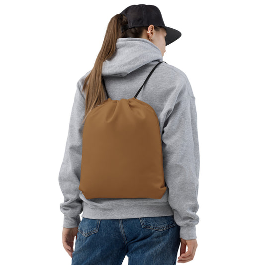 A person shown from the back wearing a plain brown drawstring backpack over a gray hoodie and blue jeans, against a clean white studio background. Lightweight Minimalist Solid Natural Wood Drawstring Bag