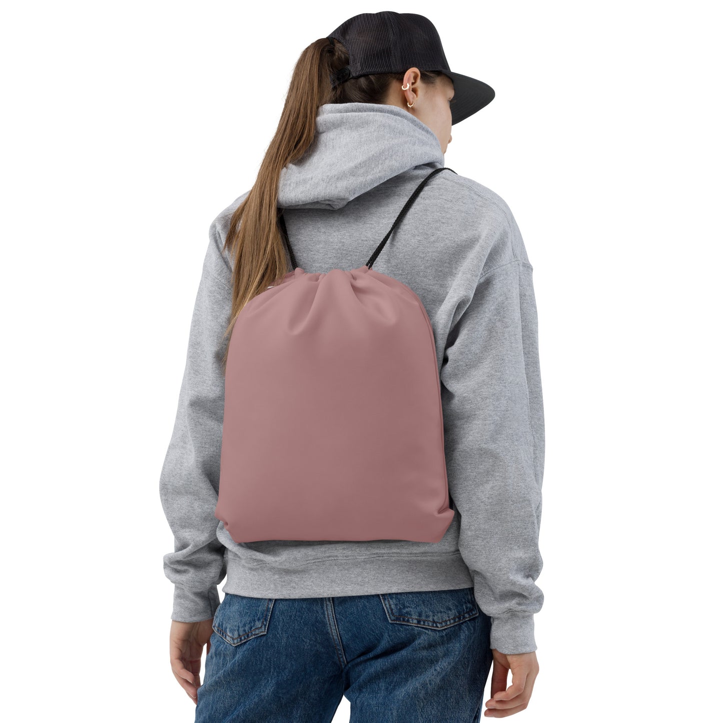 A person shown from the back wearing a dusty rose drawstring backpack over a gray hoodie and blue jeans, against a plain white background. Minimalist Solid Rosy Brown Durable Drawstring Bag