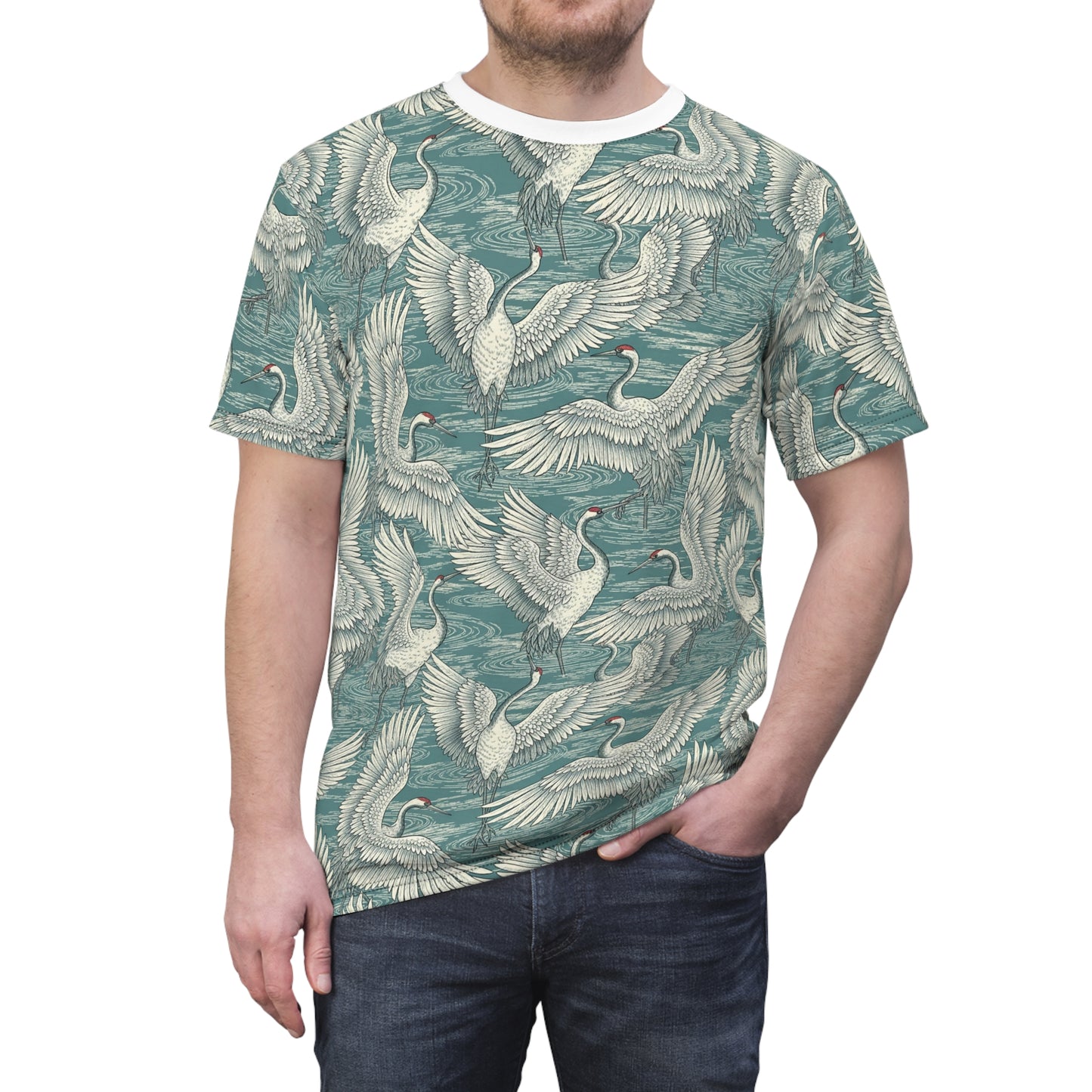 A man wearing a short-sleeve crewneck t-shirt with an all-over print of white cranes on a teal background, paired with dark blue jeans, against a plain white studio background. Minimalist Vintage Japanese Crane Pattern T-Shirt Casual Wear