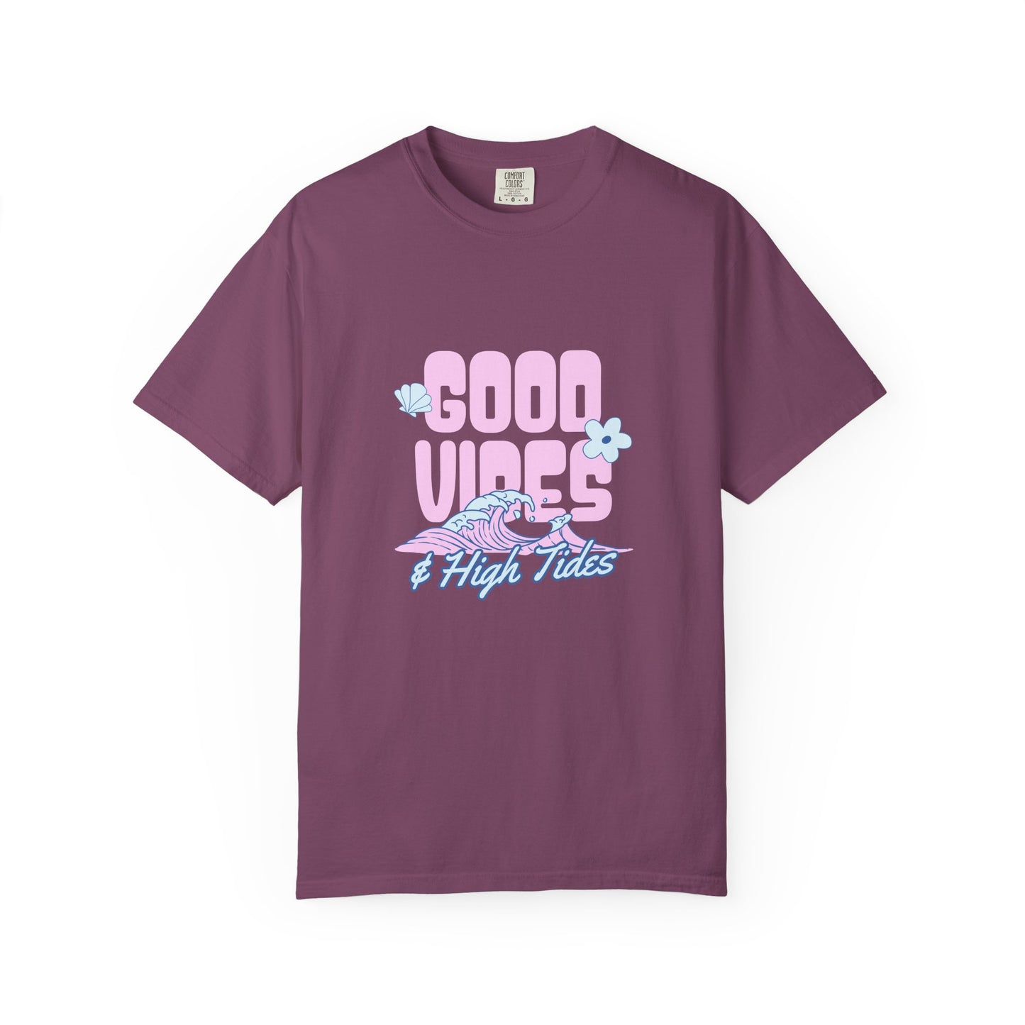 A short-sleeve crewneck t-shirt in a dusty plum purple color, featuring a retro-style graphic on the chest that reads 'GOOD VIBES & High Tides' in pink and light blue, accompanied by a pink and blue wave illustration and small light blue flowers.
