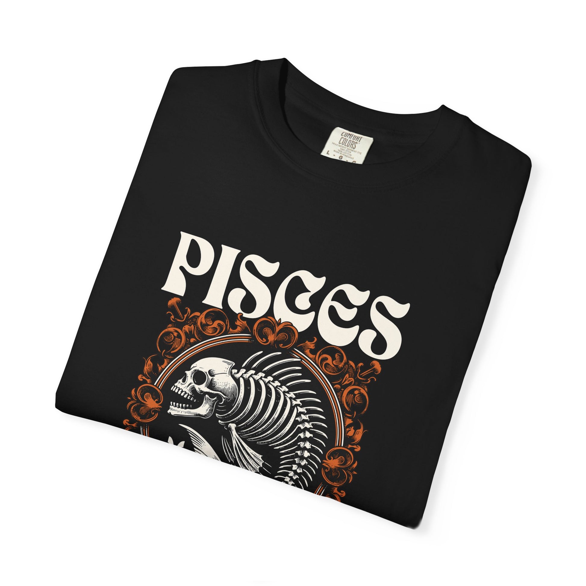 A folded black t-shirt featuring a graphic print of a white skeleton and the word 'PISCES' in a stylized white font, with orange decorative swirls, on a plain white background.