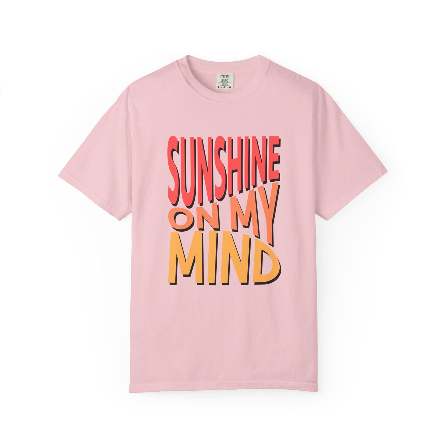 A light pink short-sleeve crewneck t-shirt featuring a bold graphic text print on the front that reads 'SUNSHINE ON MY MIND' in red, orange, and yellow 3D-style lettering with black outlines, displayed against a clean white background. Trendy Sunshine On My Mind Summer Vibes Graphic T-Shirt for Casual Wear